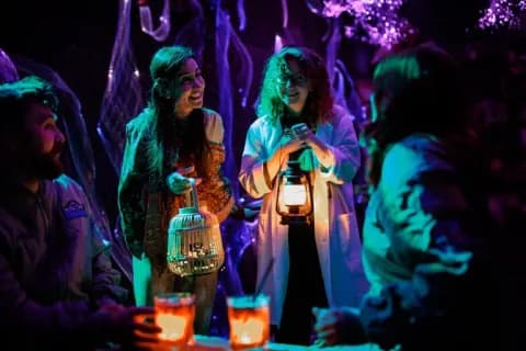 Guests exploring AVORA with lanterns in a violet-lit world